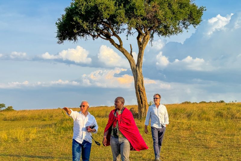 Guests are enjoying a guided walking safari through the lush landscapes of Masai Mara, surrounded by stunning wildlife and flora.